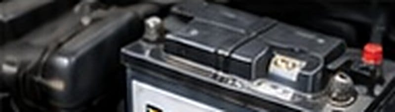 Car battery being tested under the bonnet during a service